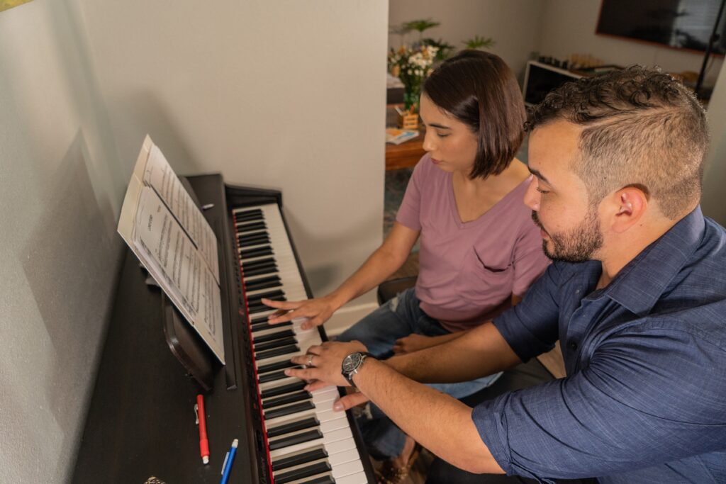 Mr. Jose showing a female student sheet music instruction on the piano